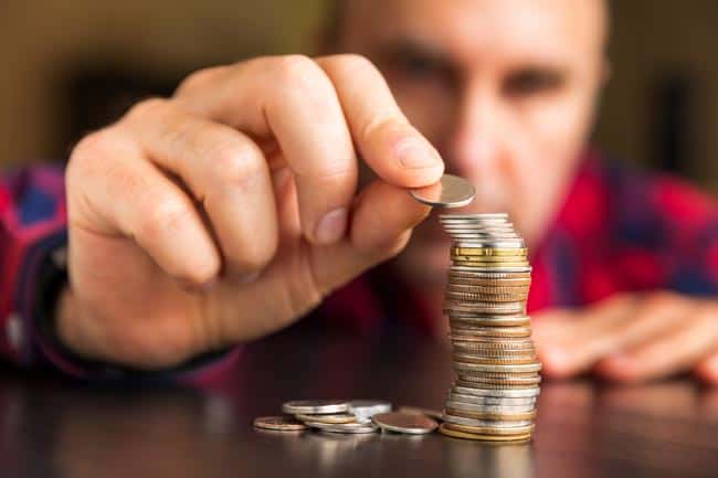 Man counting coins on table